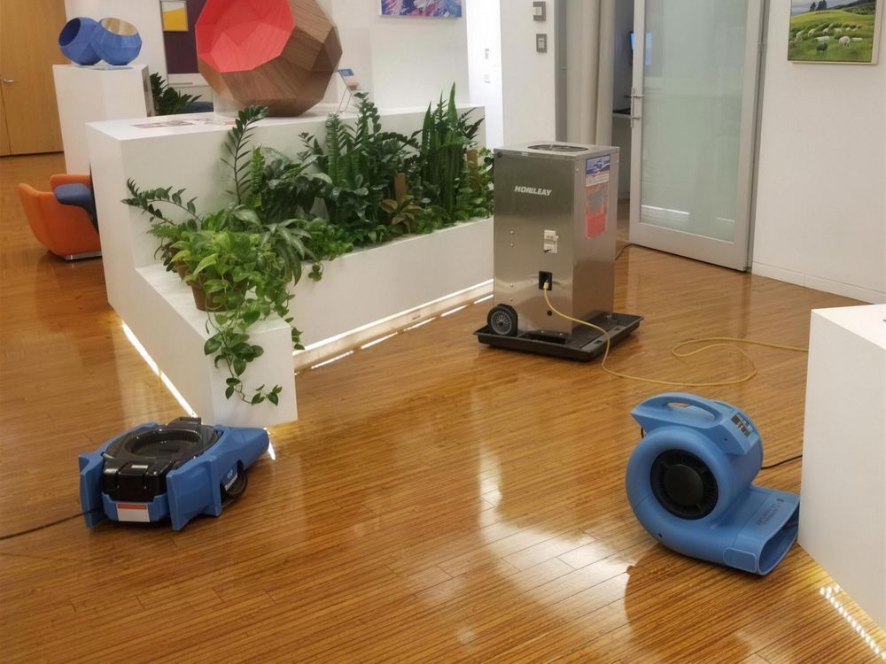 Air movers drying an office floor after water damage